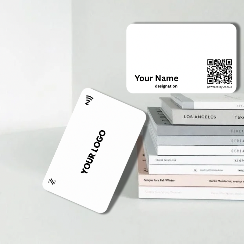 White business cards with customizable text and a QR code on a gray surface.